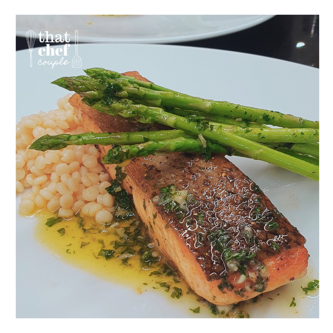 Pan-seared salmon with sauteed veggies, toasted pearl couscous and garlic butter sauce